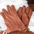 Braune Rorschach-Lederhandschuhe als Paar auf weißem Schal